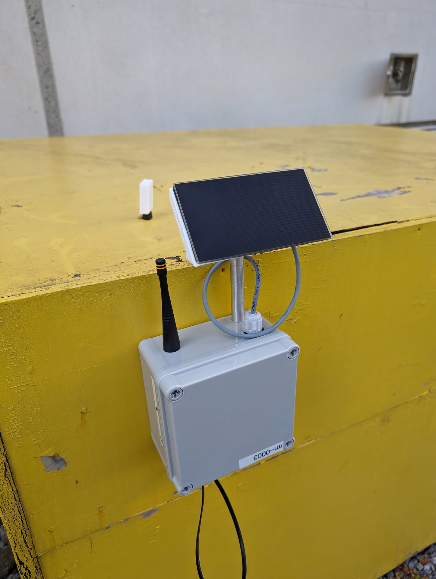A solar-powered sensor enclosure mounted on the rooftop bench