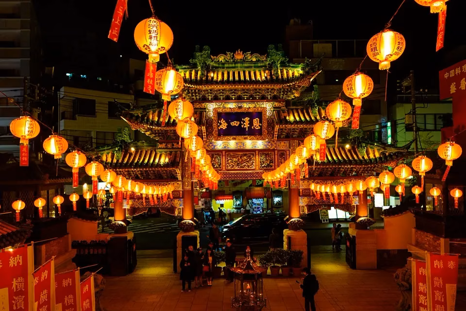 A Chinatown gate at night hung with rows of red lanterns