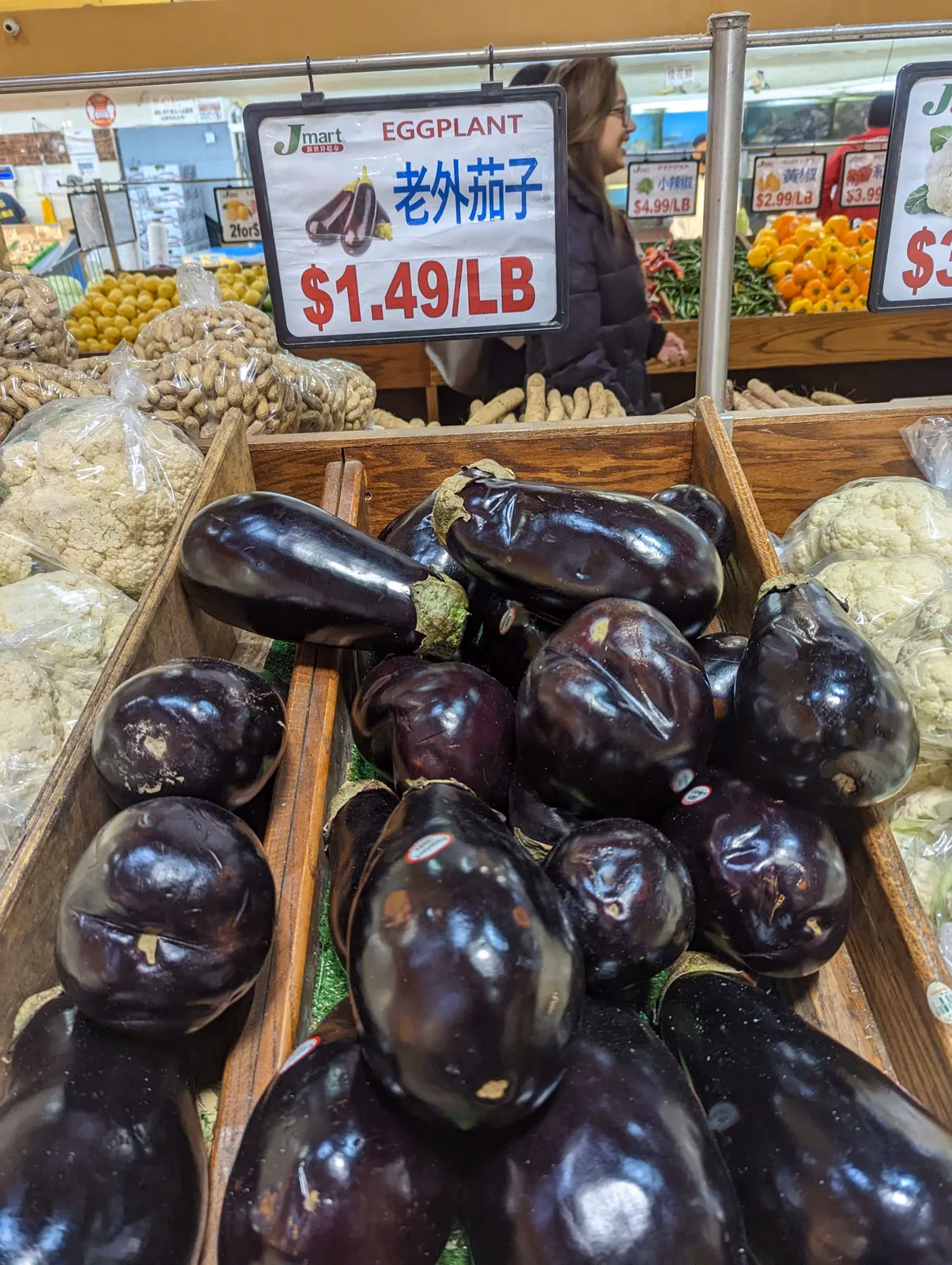 Handwritten market sign in a Flushing grocery reading “Laowai eggplant”