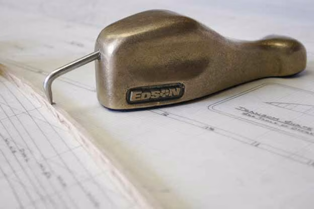 An Edson bronze spline weight (duck) resting on lofting drawings